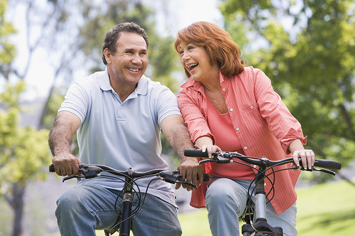 pilates-for-injury-rehabilitation-heal-faster-get-back-to-active-lifestyle-personalized-reformer-workout-mat-exercises Happy couple riding bikes outside in nature
